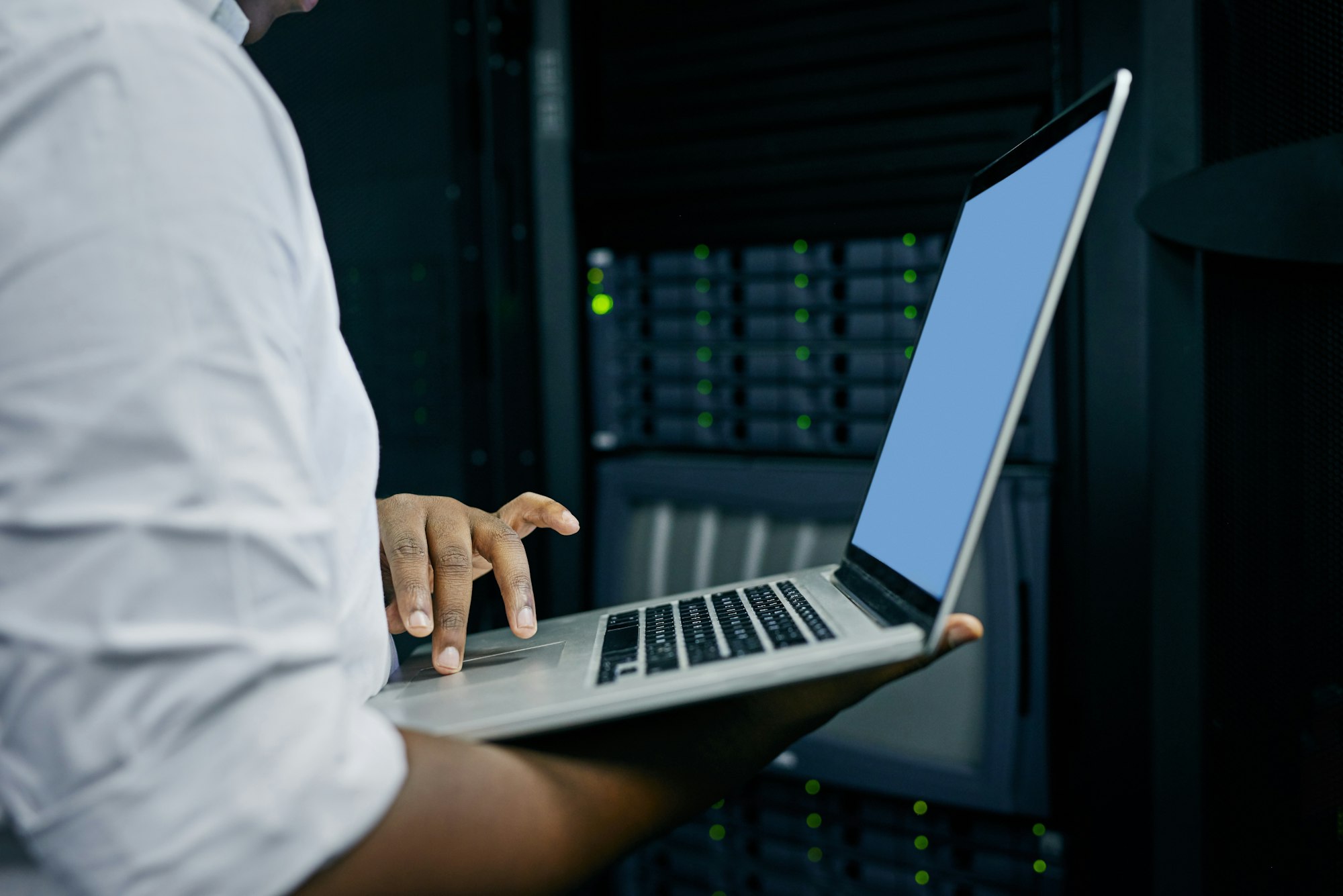 Cropped shot of an IT technician using a laptop while working in a data center